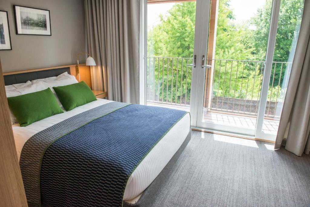 a bedroom with a bed and a large window at West Court- Jesus College in Cambridge