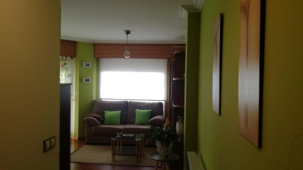 a living room with a couch and a window at Caracas in Lalín
