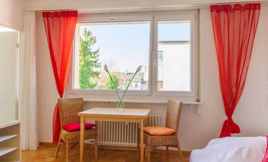 um quarto com uma mesa e cadeiras e uma janela em Apartment am Rhein em Basileia