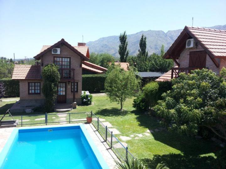 uma casa com piscina em frente a uma casa em Cabañas Euzkadi em Merlo
