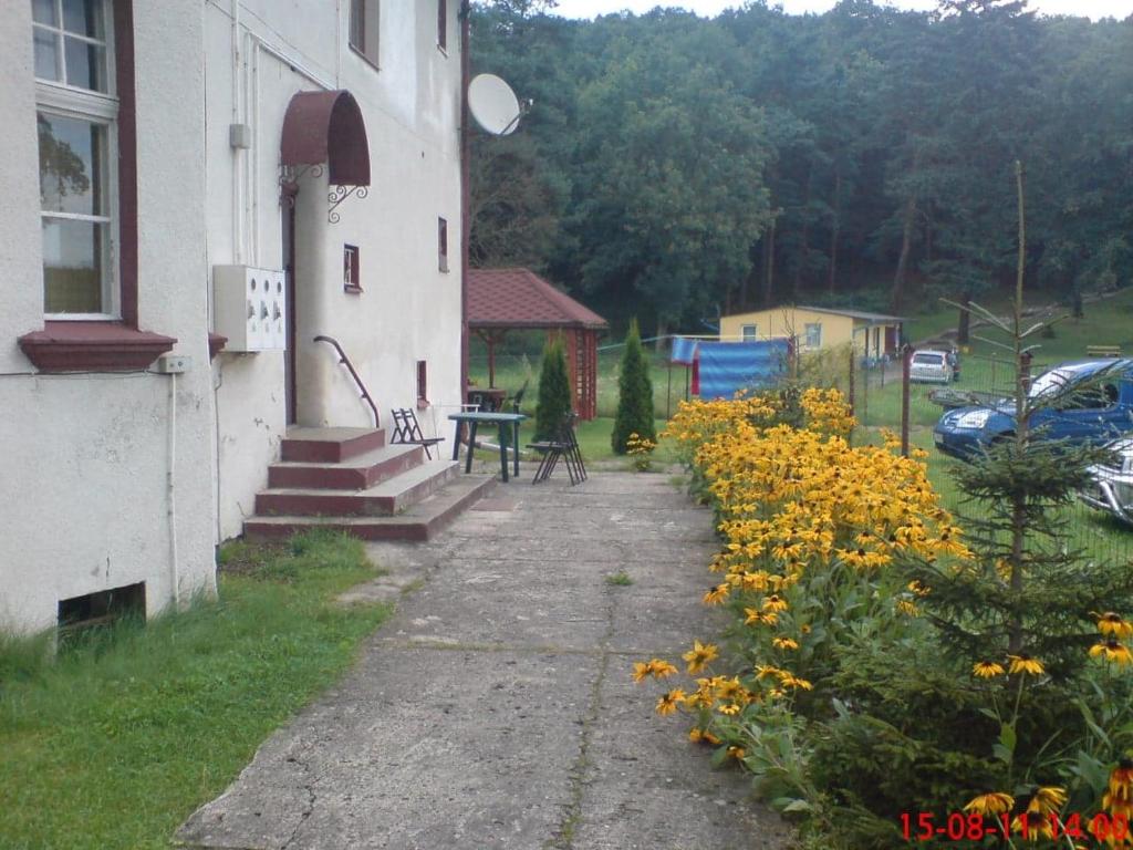 a building with a table and yellow flowers next to it at Apartament u Barbary in Wisełka