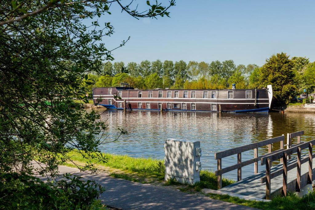 a boat is docked on the water next to a bench at Boat Hotel De Barge in Bruges
