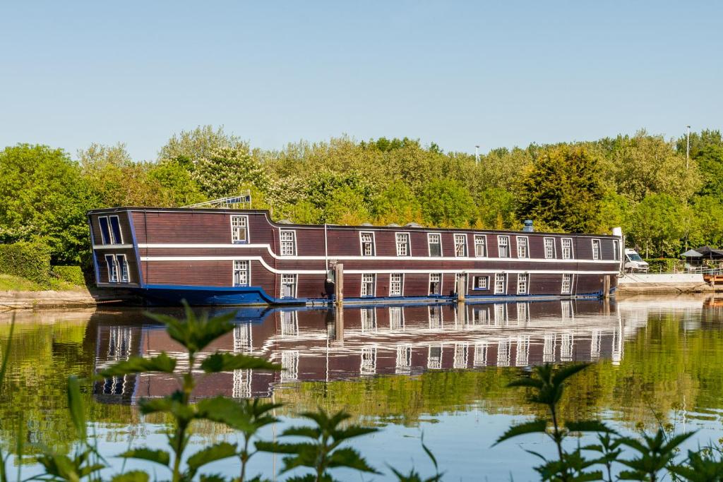 a house boat is docked on the water at Boat Hotel De Barge in Bruges