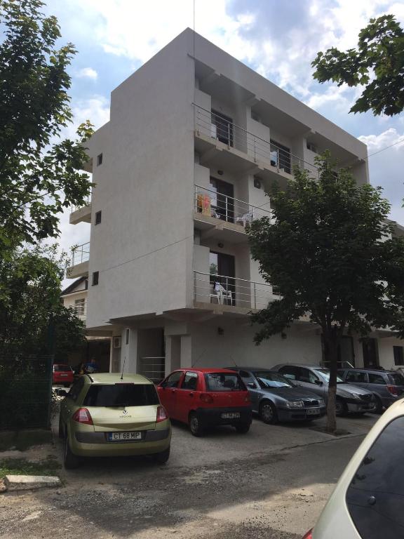 a white building with cars parked in front of it at Vila RAZA - locatie centrala in Eforie Nord