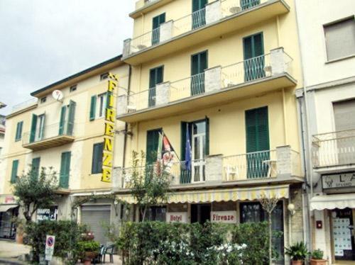 un gran edificio amarillo con un cartel. en Hotel Firenze, en Viareggio