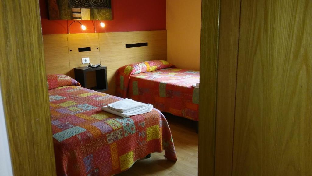 een kamer met 2 bedden en een tafel in een kamer bij Hostal-Meson Vilasante in Tríacastela
