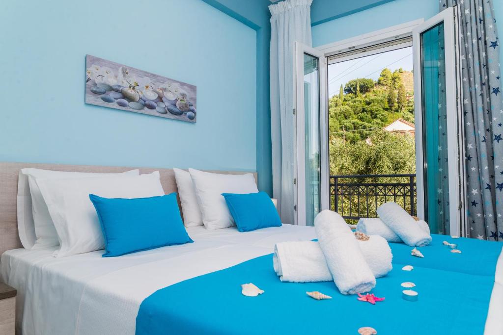 a bedroom with two beds and a large window at Esmeralda Zante House in Argasi