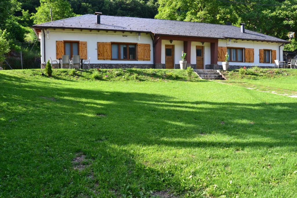 uma casa com um grande relvado em frente em Les casetes Vall de Boi em Barruera