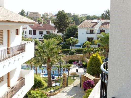 einen Balkon mit Blick auf den Pool und die Gebäude in der Unterkunft Ashanti Club Luxury Holiday Apartment in L’Alfàs del Pi