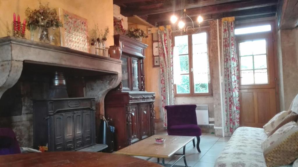 a living room with a fireplace and a couch at Gite de charme au coeur de la Bourgogne in Santigny