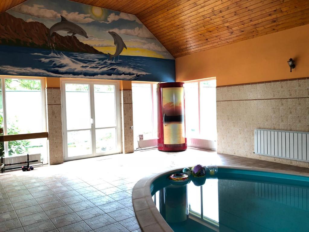 ハイドゥーナーナーシュにあるCzifra Vendégházの大きなお部屋で、建物内にスイミングプールがあります。