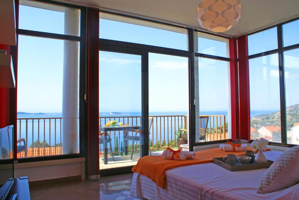 a bedroom with large windows and a view of the ocean at Apartments La Perla in Mlini