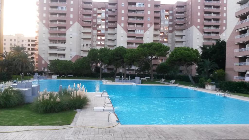 a large swimming pool in a city with tall buildings at Apart. BREZO Nova-Canet. Playa in Canet de Berenguer