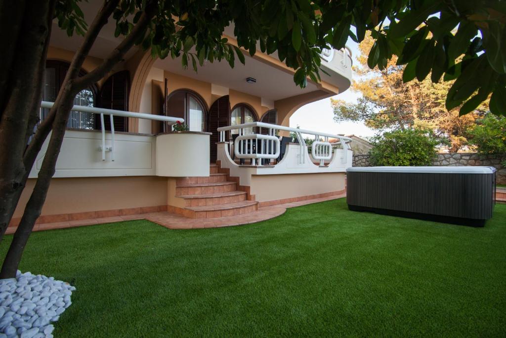 a house with a green lawn in front of it at Villa Royale in Krk