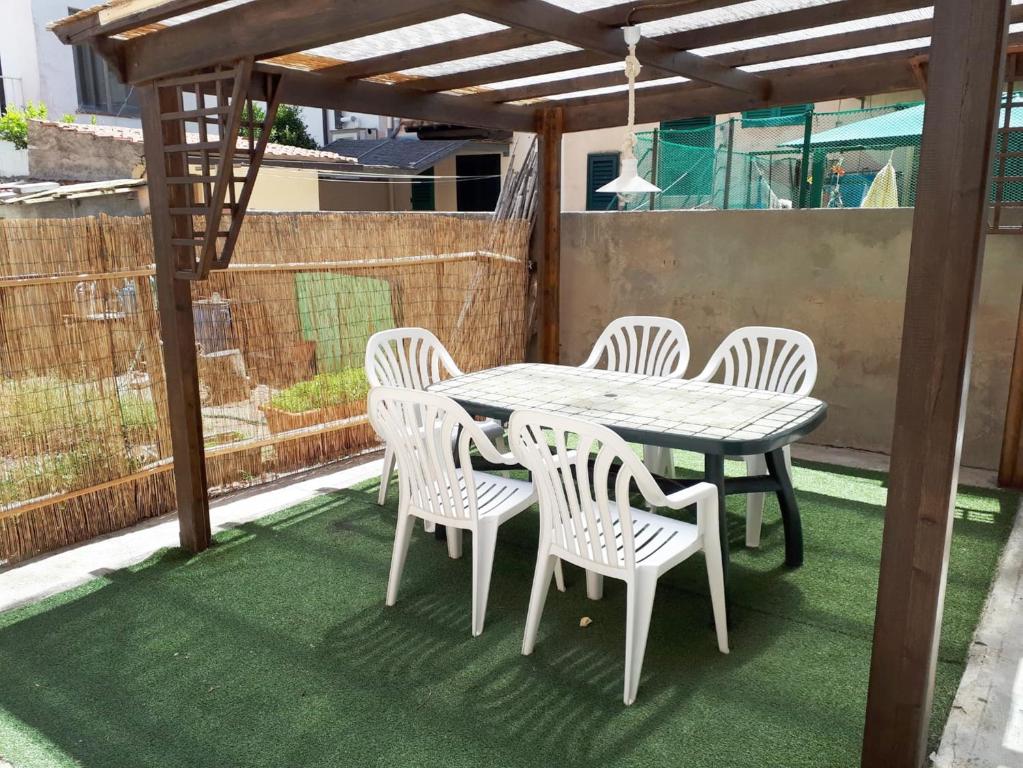 une table et des chaises en bois sur une terrasse dans l'établissement Casa Ada a Marina di Cecina by Zoom In Earth, à Marina di Cecina