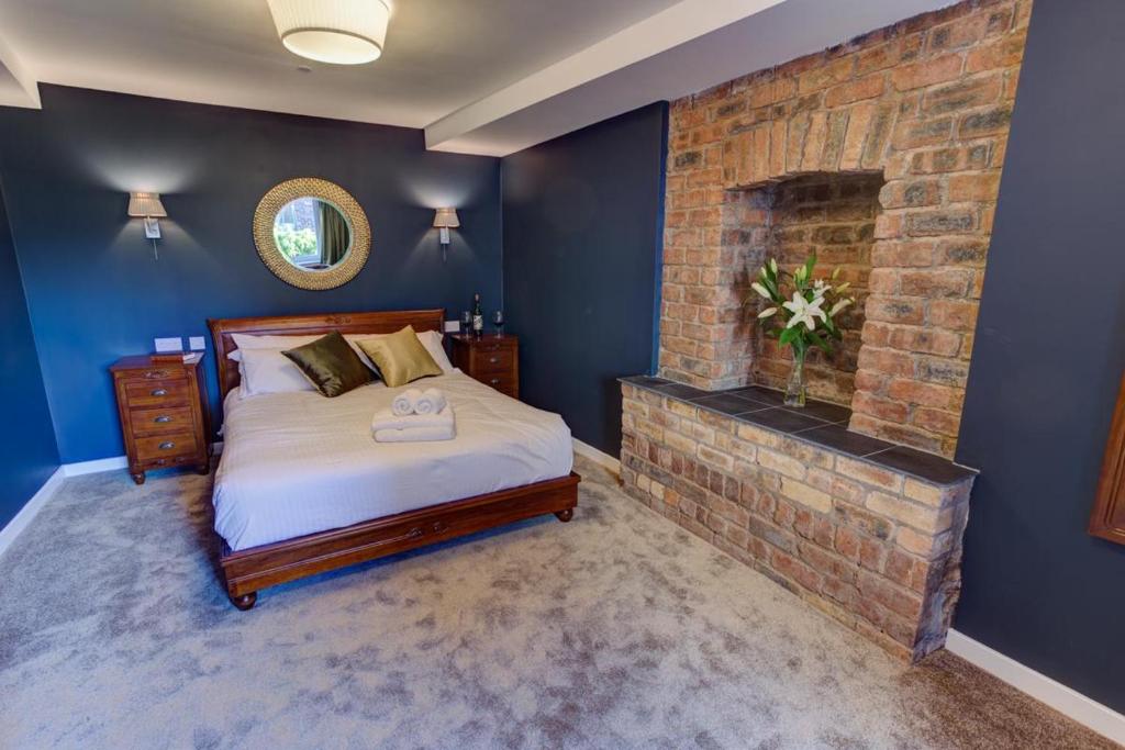 um quarto com uma cama e uma lareira de tijolos em Friars Wynd Hotel em Stirling