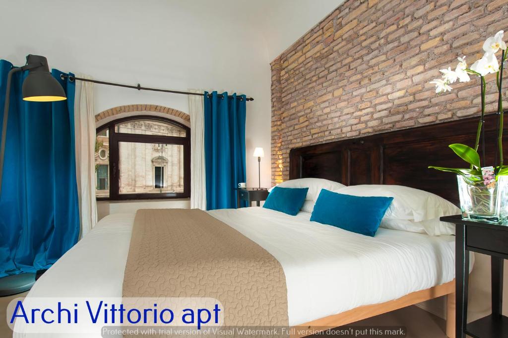 1 dormitorio con 1 cama grande y cortinas azules en Corso Vittorio Apartments, en Roma