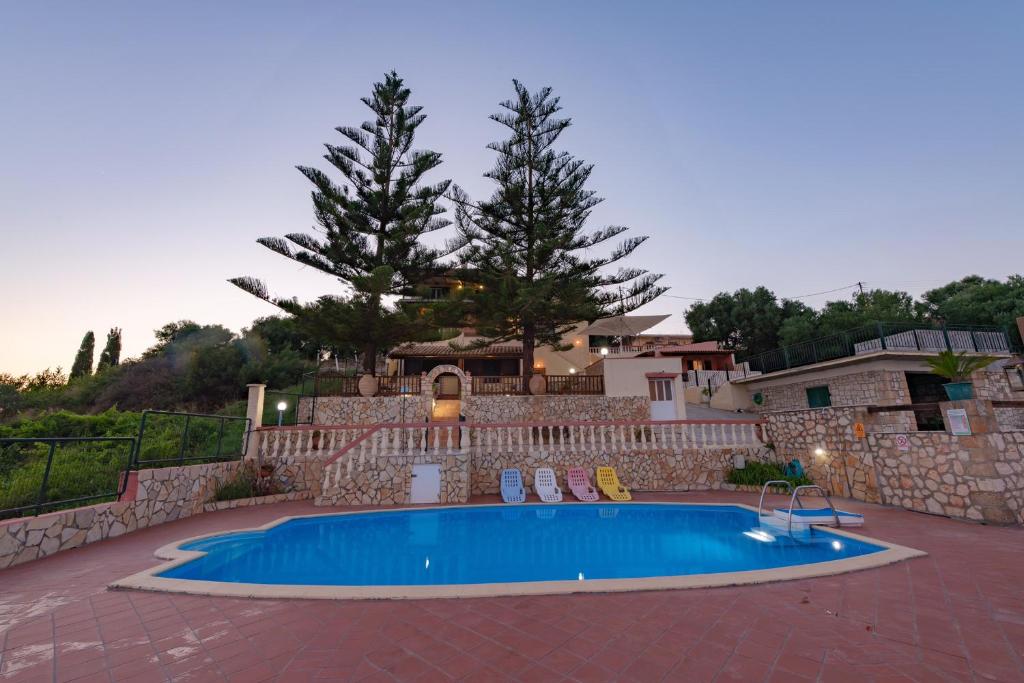 a swimming pool in front of a house at Kefalonian 360° Sunrise in Kaligata