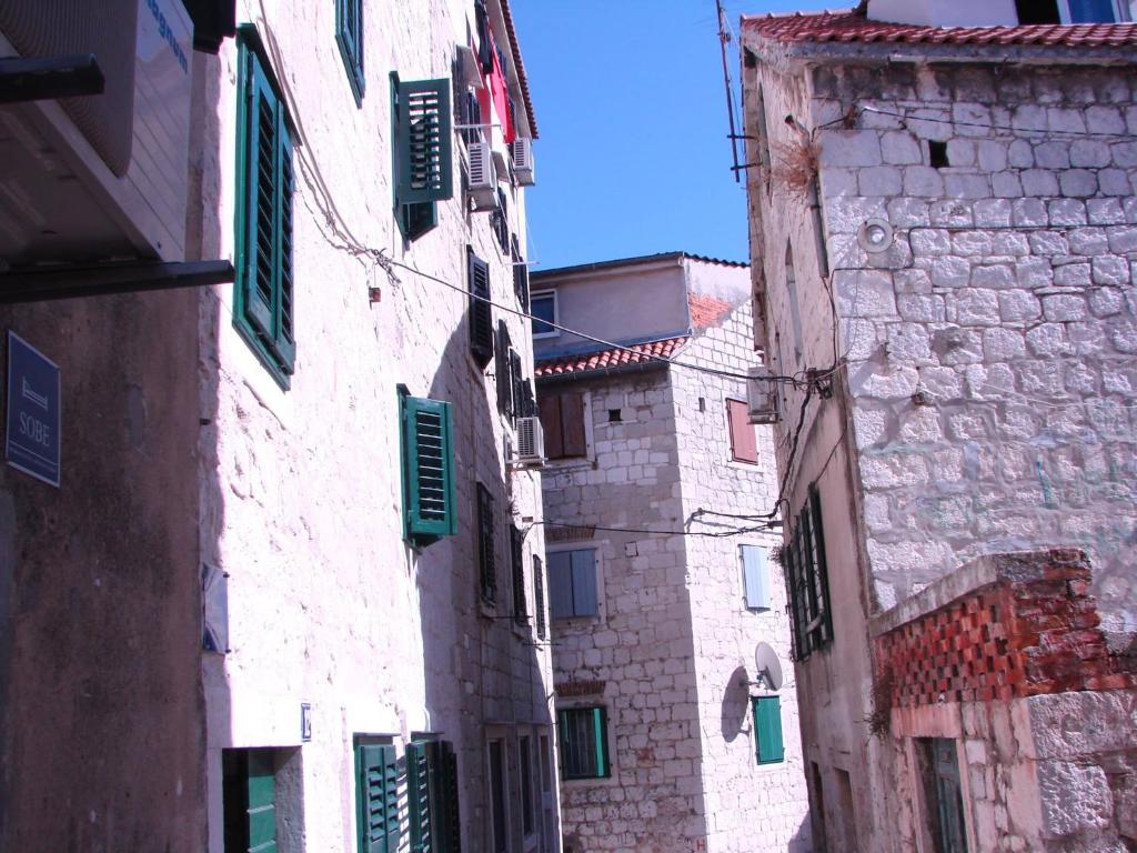 un callejón con edificios y persianas verdes en una calle en Cosy accommodation in the center of Split, en Split