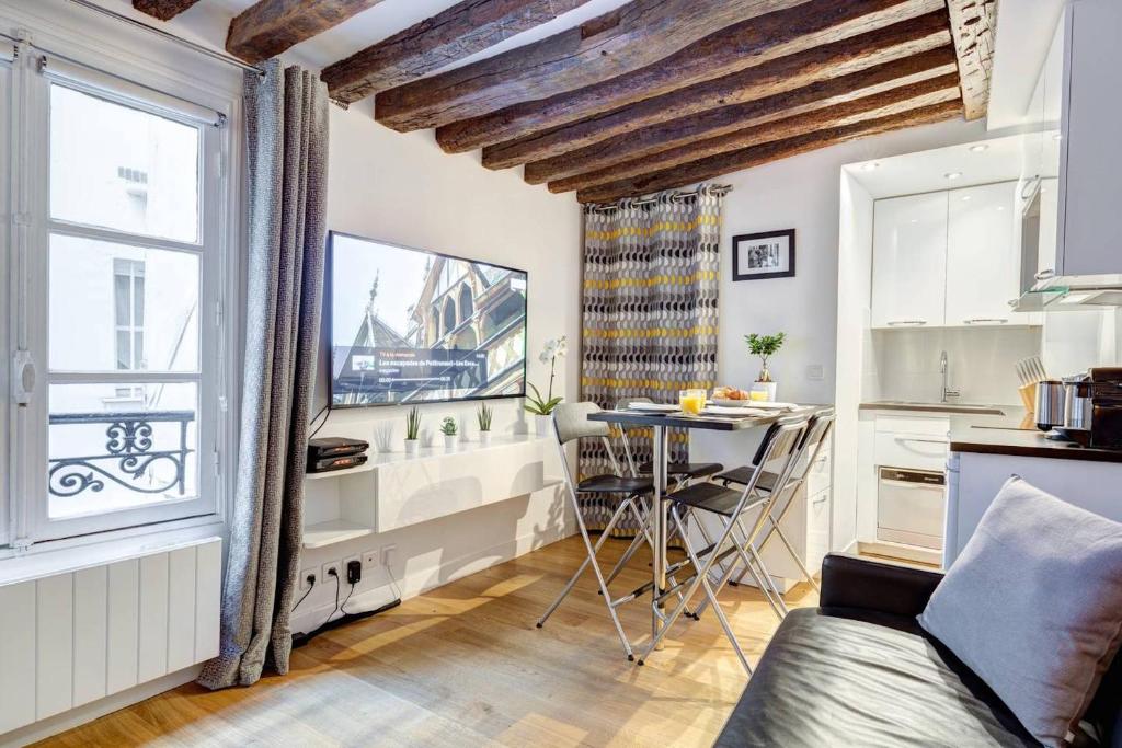 - un salon avec une table et une fenêtre dans l'établissement Quiet, Cozy, Design Apartment in Paris, à Paris