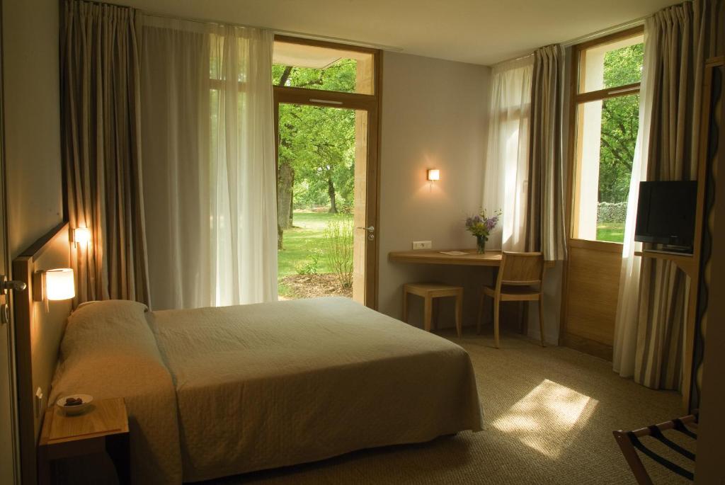 Postel nebo postele na pokoji v ubytování Hôtel Les Esclargies