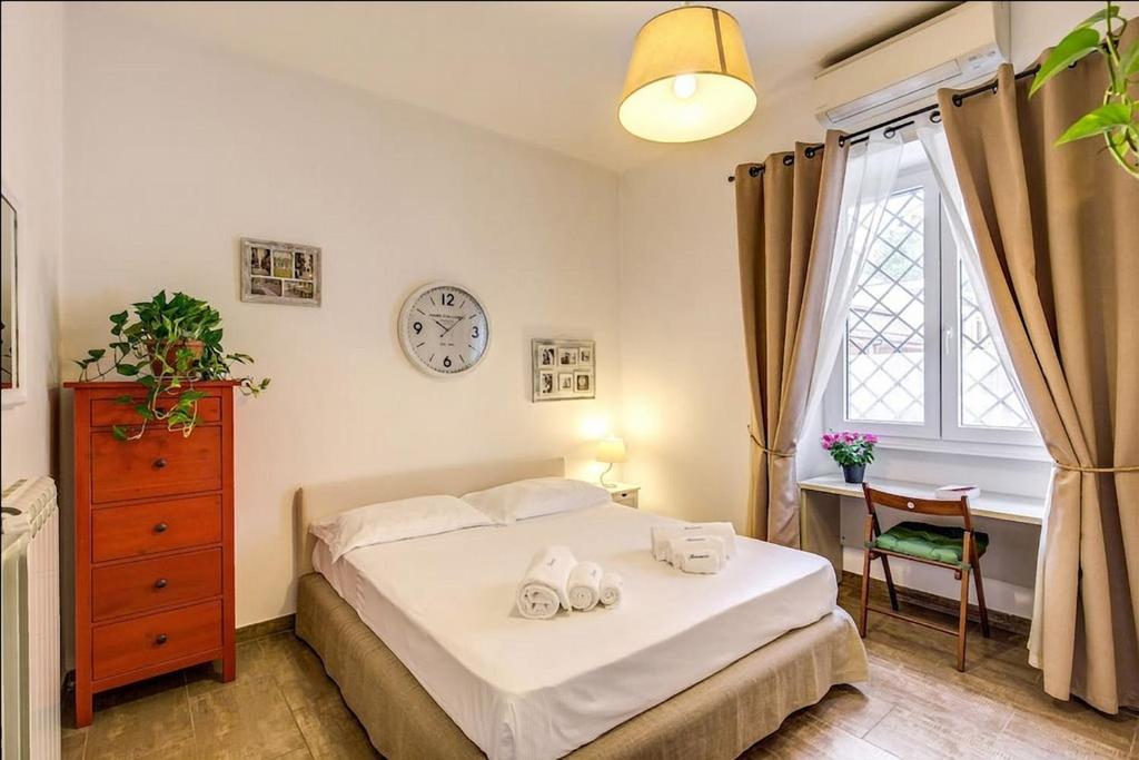 ローマにあるCuore di Florio Apartmentのベッドルーム1室(ベッド1台、デスク、時計付)