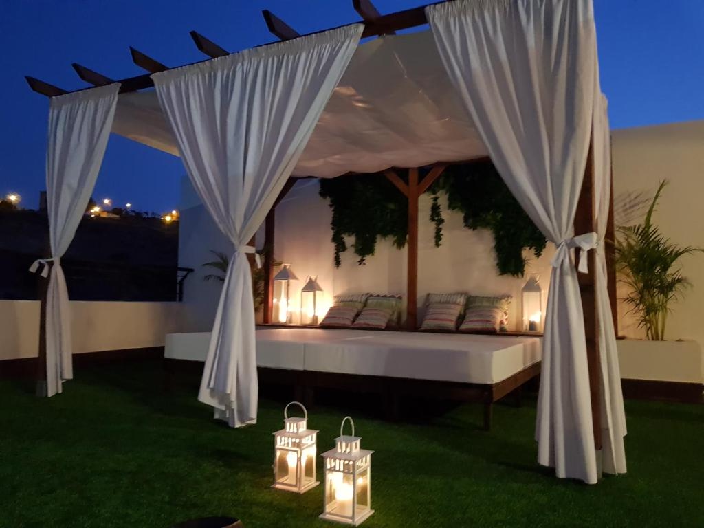uma cama num quarto com luzes na relva em Villa Montegolf em Telde