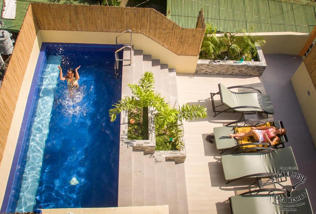 una piscina con 2 personas en el agua en Papa Freds Beach Resort, en Puerto Galera