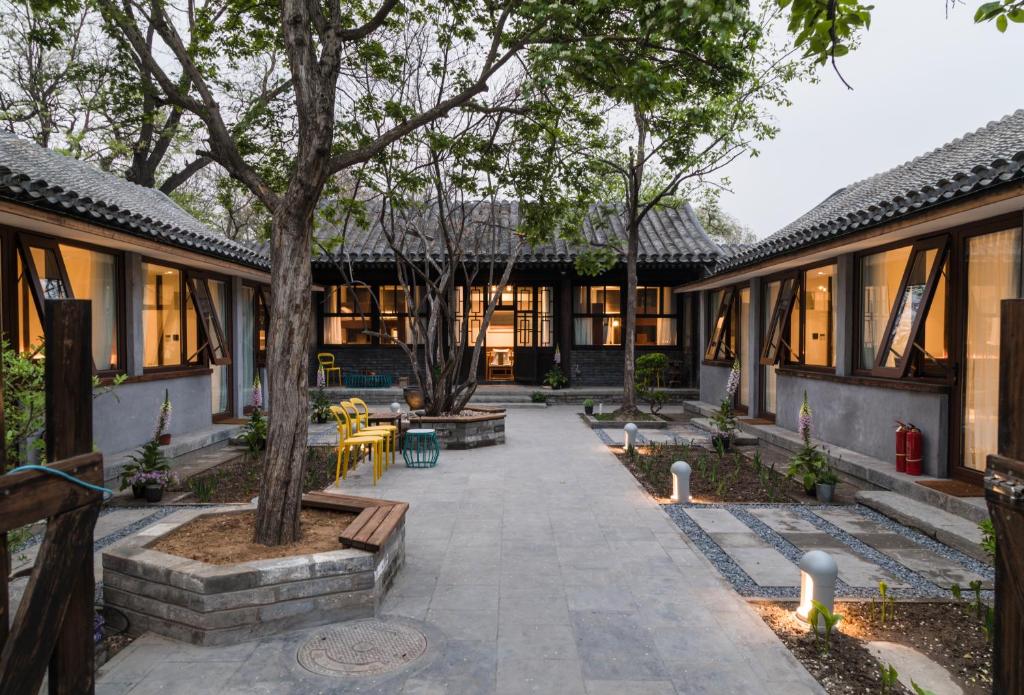 a courtyard of a building with a tree and benches at Courtyard Guesthouse, Beijing in Beijing