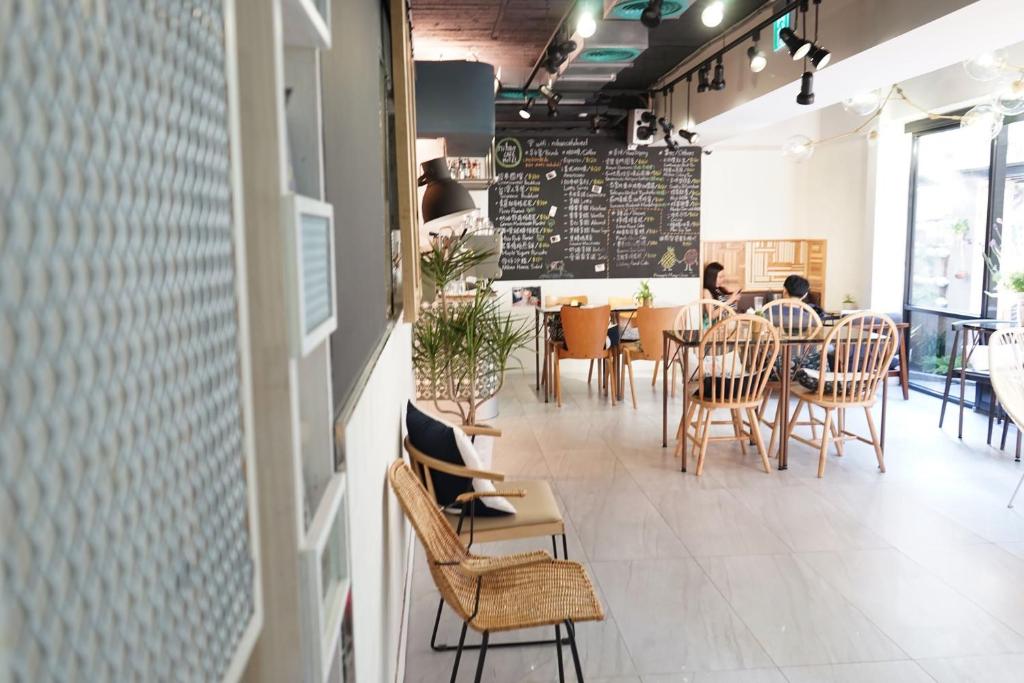 een restaurant met stoelen en tafels en een schoolbord bij NiHao Café Hotel in Taipei