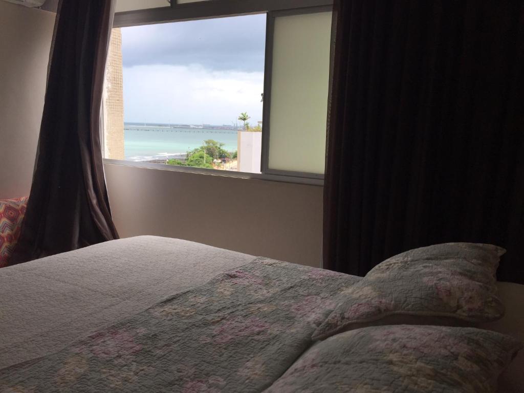 1 dormitorio con cama y ventana con vistas al océano en Stúdio Beira Mar 1004, en Fortaleza