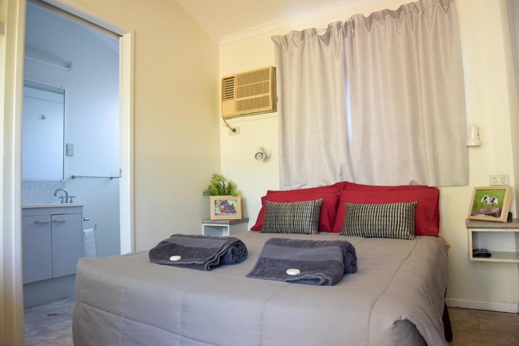 a bedroom with a large bed with two bags on it at Mataranka Roadhouse in Mataranka