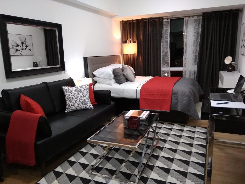 une chambre d'hôtel avec un lit et un canapé dans l'établissement Abreeza Studio by Lustra, à Davao