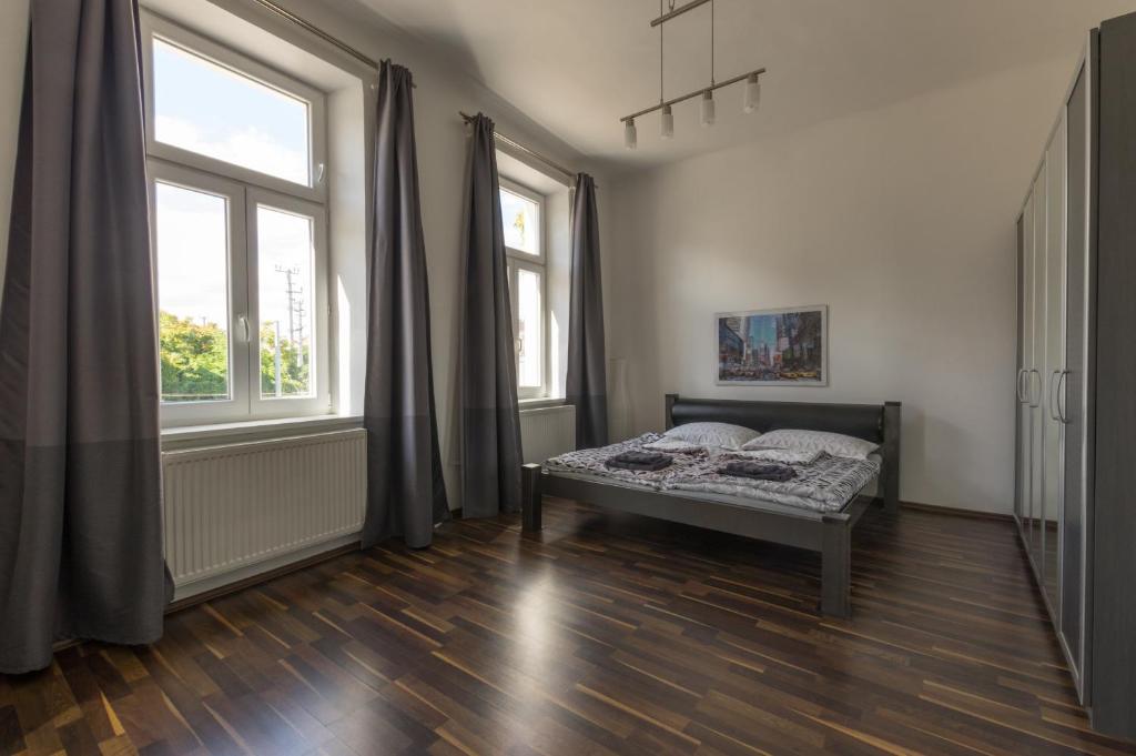 a bedroom with a bed and two windows at Spacious Apartment in Center with Terrace in Vienna