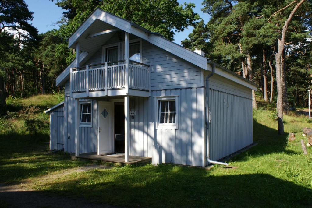 a small blue building with a porch and a balcony at Ferienhaus-Kinderlieb in Baabe