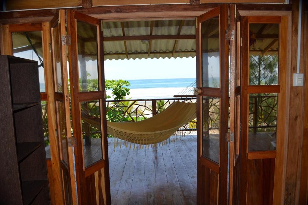 a hammock in a room with a view of the ocean at The Sea Garden House in Olón