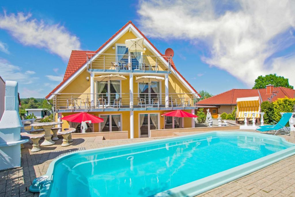 a house with a swimming pool in front of a house at Villa Europa in Heringsdorf