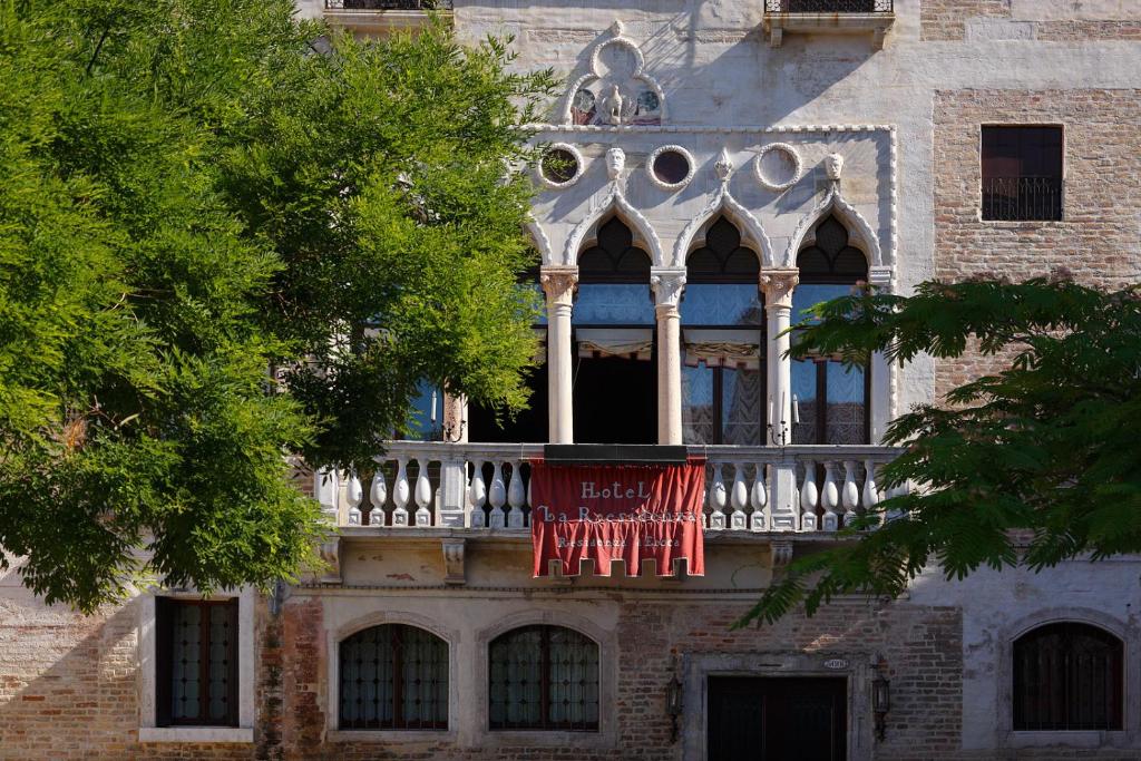 un edificio con un balcone con una bandiera di Hotel La Residenza a Venezia
