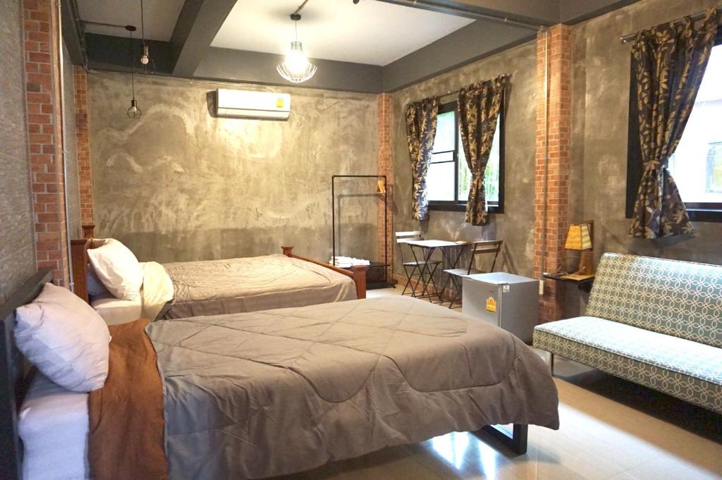 - une chambre avec deux lits, une chaise et une table dans l'établissement Sawatdee Guesthouse the Original, à Bangkok