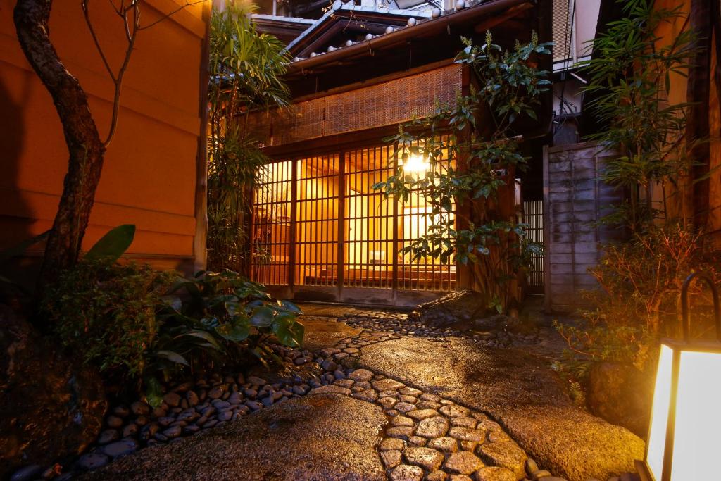 an entrance to a building with a gate at night at Ryokan Sanga in Kyoto