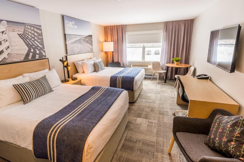 een hotelkamer met 2 bedden en een bank bij Mill River Resort in OʼLeary