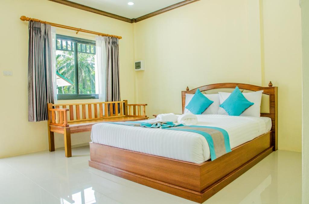 a bedroom with a large bed and a window at Changsi Resort-Krabi in Krabi