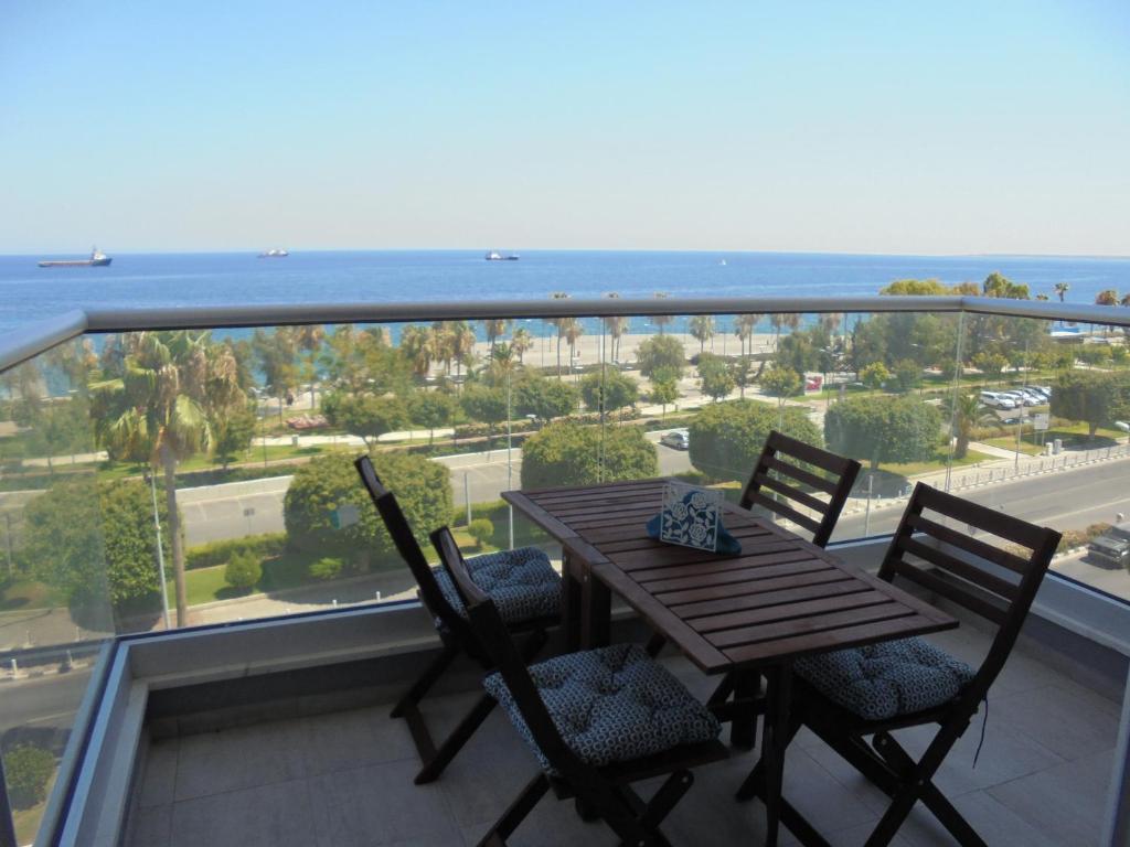 een tafel en stoelen op een balkon met uitzicht op de oceaan bij Kermia Court - Beach-front, modern 2 bedroom -sleeps 6 in Limassol
