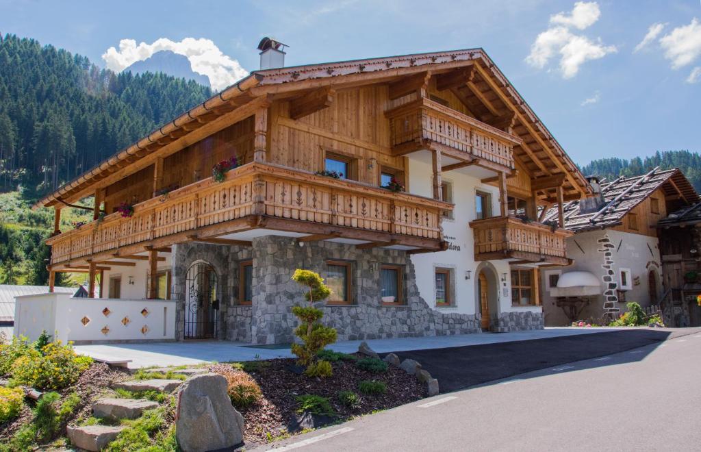 a large wooden house with a balcony at Apartments Edera in Selva di Val Gardena