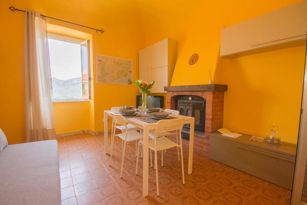 een keuken met een tafel met stoelen en een open haard bij pedalando sul mare in Finale Ligure
