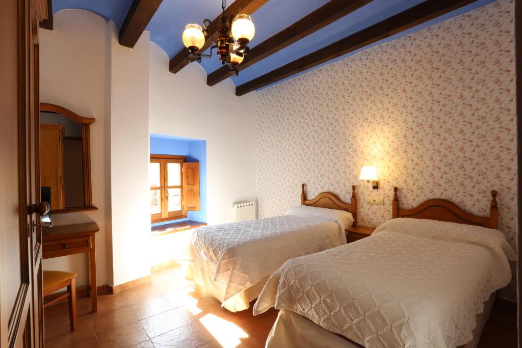 a bedroom with two beds and a window at Hospedería Sádaba in Sádaba