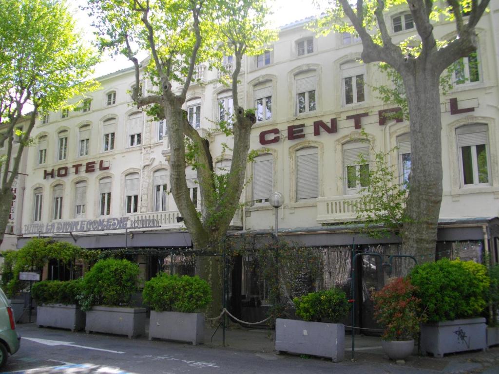 un edificio blanco con un cartel. en Hôtel Central, en Carcassonne