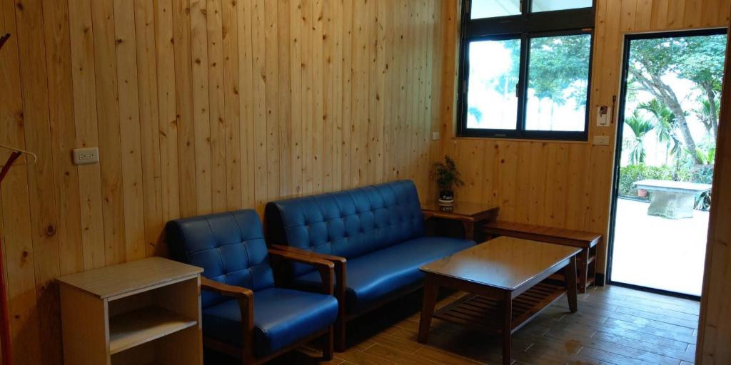 a waiting room with a blue couch and a table at Zhong Ming Ju Taoyi Fang in Fanlu