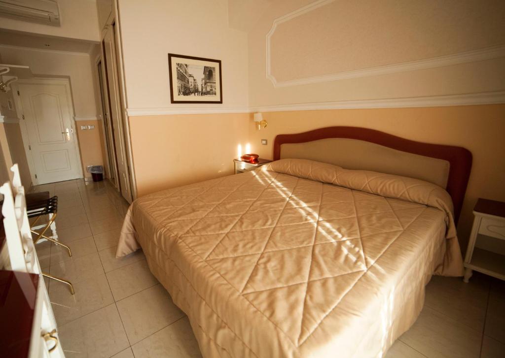 a bedroom with a large bed in a room at Hotel Gran Duca in Livorno