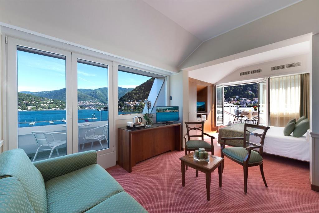 um quarto de hotel com um sofá e uma cama e janelas em Hotel Barchetta Excelsior em Como